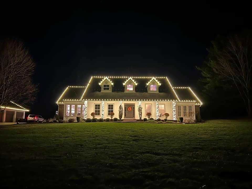 Cape-style home with warm white C9 lights outlining every roofline at night